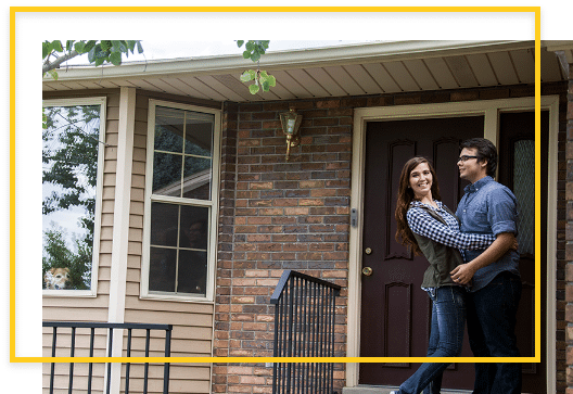 Happy couple on their front porch with doorbell camera
